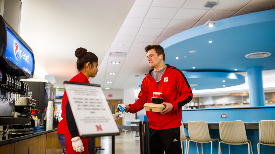 Dining Services handing a drink